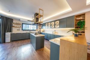 a large kitchen with blue cabinets and a island at LİV Villa in Marmaris