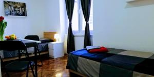 a room with two beds and a table and a window at Pula-Center Apartments and Rooms in Pula