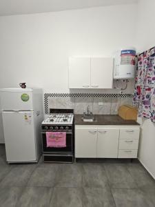 eine kleine Küche mit einem Herd und einem Kühlschrank in der Unterkunft Departamento CR in Alta Gracia