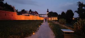 a person walking down a path next to a wall at Studio Żdanowska Zamość in Zamość +5 photos