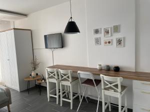 科帕奥尼克Residence Hills Lux Hotels & Spa Kopaonik的厨房配有木桌和白色椅子