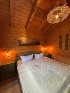 a bedroom with a bed in a wooden room at Blockhaus Holzzeit im Bayerischen Wald in Stamsried +32 photos