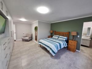 a bedroom with a bed and a chair and a television at Gezondheid in Velddrif +11 photos