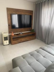 a living room with a television and a couch at Casa São João del Rei Proximo a Tiradentes in São João del Rei