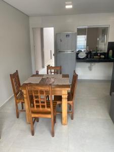 a dining room table with chairs and a refrigerator at Casa São João del Rei Proximo a Tiradentes in São João del Rei