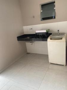 a bathroom with a sink and a counter with a mirror at Casa São João del Rei Proximo a Tiradentes in São João del Rei