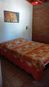 a bedroom with a bed with a quilt on it at Cabañas las marias 3 in Tanti Nuevo +5 photos