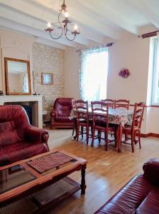 a living room with a table and chairs at Gîtes Chez Belliveau in Meursac