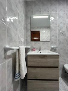 un baño con lavabo y espejo en Apartamento RUAL, en Sanxenxo 19 fotos más