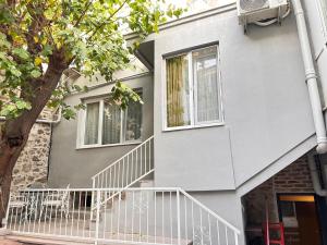a house with a white staircase leading up to a window at Akraios Guesthouse Beautiful Stone House in Konak in Konak