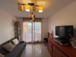 a living room with a couch and a flat screen tv at Villa Eric in Roldán