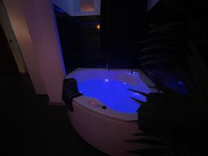 a white bath tub with blue water in a room at Love room Buenas noches SPA et bord de mer in La Seyne-sur-Mer