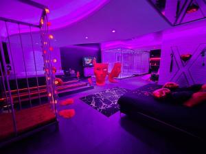 ein lila Zimmer mit einem Bett und einer Schaukel in der Unterkunft Les Secrets Rooms in Hagondange