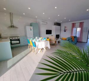 Una cocina y una sala de estar con mesa y sillas. en Casa Calma, en Conil de la Frontera