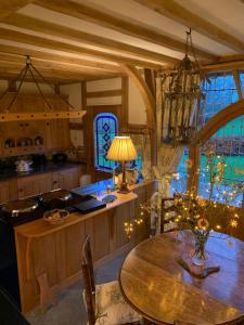 a kitchen with a wooden table and a dining room at Ebony Cottage in Tenbury