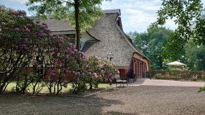 a house with purple flowers in front of it at De Leev - Landhaus Lübbertsfehn in Ihlow