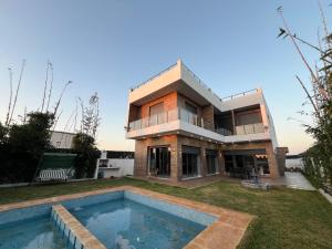 a house with a swimming pool in front of it at villa lux in Kenitra