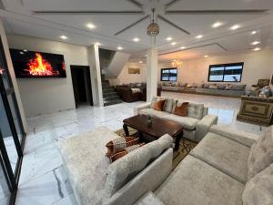 a living room with couches and a fire on the wall at villa lux in Kenitra