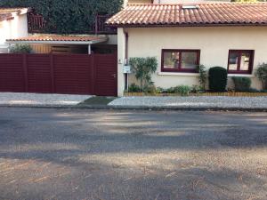 una casa con una recinzione rossa davanti di Petite maison bleue Dune du Pyla 4 personnes 2 vélos a La Teste-de-Buch
