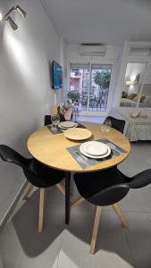 een houten tafel en stoelen in de woonkamer bij Benalmadena Minerva Apartamento con gran piscina in Benalmádena