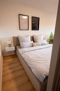 a bed with white sheets and pillows in a room at Central apartment near Basel - Buisness&Holiday in Rheinfelden