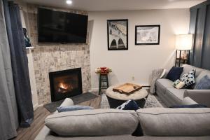 ウォータービル・バレーにあるCozy Ski Condoのソファと暖炉のあるリビングルーム
