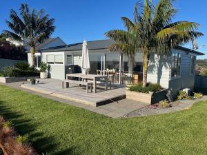 a house with a patio with a table and an umbrella at The City Cottage in Auckland