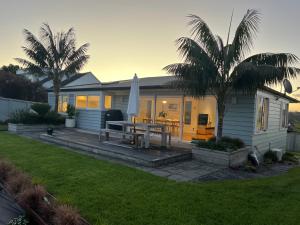 a house with a patio with a table and an umbrella at The City Cottage in Auckland +8 photos