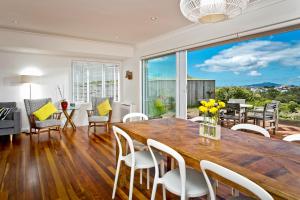 a dining room and living room with a large table and chairs at The City Cottage in Auckland