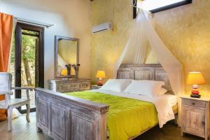 ein Schlafzimmer mit einem Holzbett mit einer gelben Decke in der Unterkunft Villa Acqua, a luxury villa with private pool, 10 mins drive from the beach in Marantochori