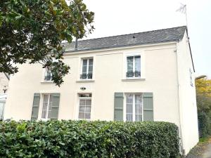 a white house with windows and a hedge at "Les Magnolias" Charmante maison de 4 chambres au coeur des Châteaux de la Loire in Champigné