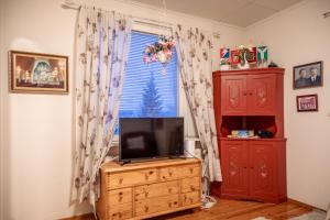 a living room with a tv and a window at Villa Blue in Autti