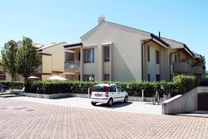 a white car parked in a parking lot in front of a building at Bombyx Inn in Bergamo +16 photos