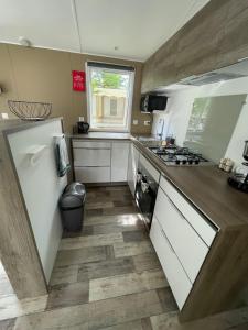 a kitchen with a sink and a stove at Mobilhome bord du lac in Parentis-en-Born
