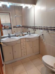 a bathroom with two sinks and a toilet at Best4Buck in Los Cristianos