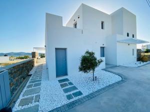 a white house with a tree in the yard at Dreamy Sunset Villa a few steps from the Beach in Pounda