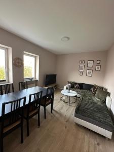 ein Wohnzimmer mit Tisch und Couch in der Unterkunft Handwerker-Lodge Ottweiler in Ottweiler