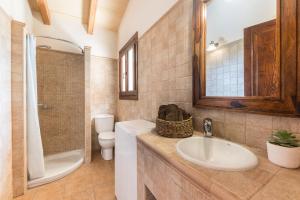 Un baño con lavabo, inodoro y espejo. en Son Sea Villa, en Campos