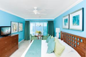a bedroom with blue walls and a bed and a table at Oyster Bay Beach Resort in Dawn Beach