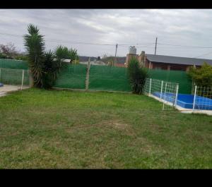 einen Zaun in einem Hof mit Tennisplatz in der Unterkunft Cabaña san Pedro de Colalao in San Pedro de Colalao