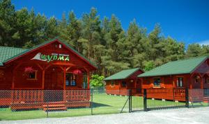 a couple of small wooden buildings with a fence at Domki Letniskowe Wydma in Bobolin