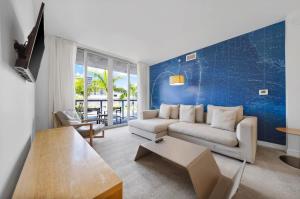 ハランデール・ビーチにある1 Bed & Kitchen at Beachwalk Luxe Pool Gym Beachのソファとテーブルのあるリビングルーム