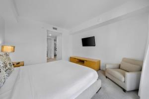 ハランデール・ビーチにある1 Bed & Kitchen at Beachwalk Luxe Pool Gym Beachのベッドとソファのある白い寝室 +31枚の写真