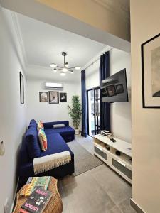 a living room with a blue couch and a tv at Beach & House''Villa Maria'' 5 min to Mareta Beach in Sagres +41 photos