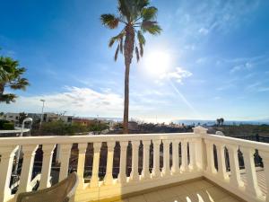 a balcony with a palm tree and the ocean at Villa Callao Salvaje 3 BR Heated Pool & Stunning Views in Adeje