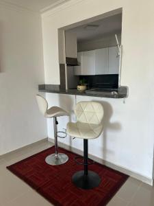 cocina con 2 taburetes y barra con microondas en Gran Apartamento frente al mar, en La Francia