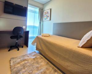 ein Schlafzimmer mit einem Bett, einem Schreibtisch und einem Stuhl in der Unterkunft BookSantos Unlimited 2506 Paraíso Vista Mar 2dor in Santos