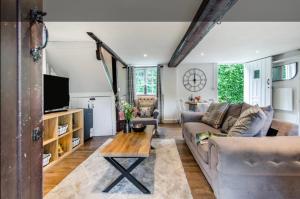 a living room with a couch and a table at Stable boys cottage in Sedgeberrow