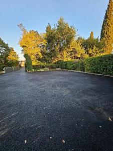 an empty parking lot with trees and a hedge at L'Esquisse Coquelicot - Parking Clim Netflix Canal in Milhaud
