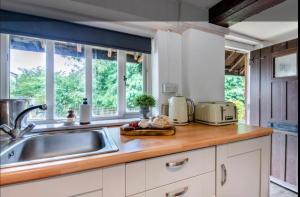 a kitchen with a sink and a counter top at Stable boys cottage in Sedgeberrow +8 photos